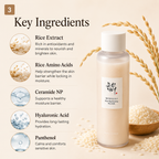 A bottle of rice extract facial toner shown on a beige background with ingredient callouts. The bottle is frosted with a white cap and a white label featuring Korean text and English reading 'Olive Hyalu-Celant Rice Extract Facial Toner.