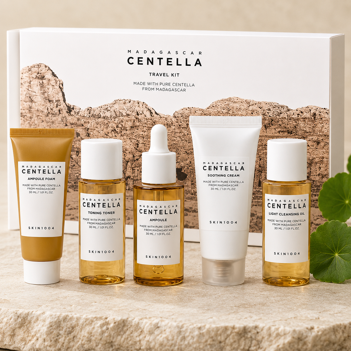 A SKIN1004 Madagascar Centella Travel Kit containing five skincare products arranged on a stone surface in front of their white and brown packaging box.