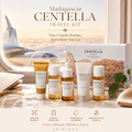 Madagascar Centella Travel Kit by SKIN1004 displayed on a marble surface with an airplane window view in the background. The set includes a white box, a gold tube, a white dropper bottle, a white tube, and a small amber bottle, with travel icons at the bottom.